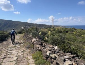 Ciclisti in mountain bike tra i sentieri e le cantine dell'entroterra di Pantelleria.